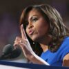 Michelle Obama confidently addressing a crowd, symbolizing strength and perseverance.