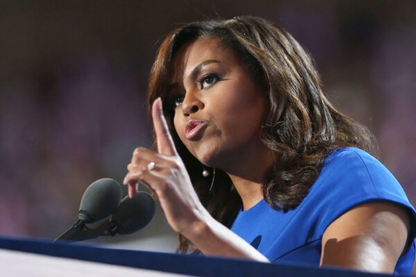 Michelle Obama confidently addressing a crowd, symbolizing strength and perseverance.